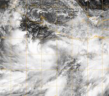 Visible satellite image of a tropical depression intensifying. The storm features a broad area of cloud cover, stretching far out horizontally from the main system. Central and southern Mexico can be seen at the top of the image.