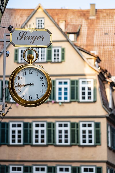 File:Uhr über dem Eingang des Juweliers Seeger in Tübingen mit Kronenstraße 19 im Hintergrund 2019.jpg