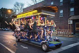 A group of people partying on a giant bike in the streets of Montreal