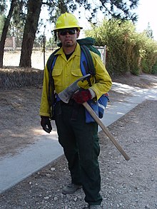 Holding a Pulaski, a wildland firefighter from the Angeles National Forest responds to a fire in Altadena, California on July 9, 2006. WilliamCervera.jpg