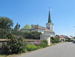 Ohradní zeď bývalé zámecké zahrady s památkově chráněným rondelem a kostel svaté Anny z roku 1908