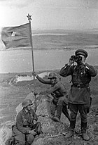 Lieutenant I. N. Moshlyak (center) and two Soviet soldiers on Zaozernaya Hill after the Battle of Lake Khasan. Battle of Lake Khasan-Red Army soldiers setting the flag on the Zaozernaya Hill.jpg