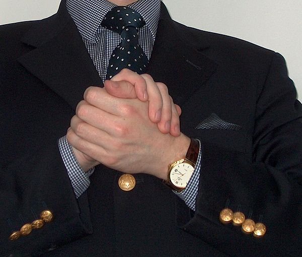 A single-breasted, reefer-style, navy blue blazer, dressed with brass buttons.