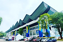 Gelora Bung Karno Aquatic Stadium. The 2016-17 renovation introduced a new, wave-shaped roof above the arena which originally only had roofs at the tribune. GBK Aquatic Stadium AG18.jpg