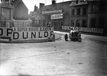 Photographie d'une voiture entrant dans un virage en épingle à cheveux