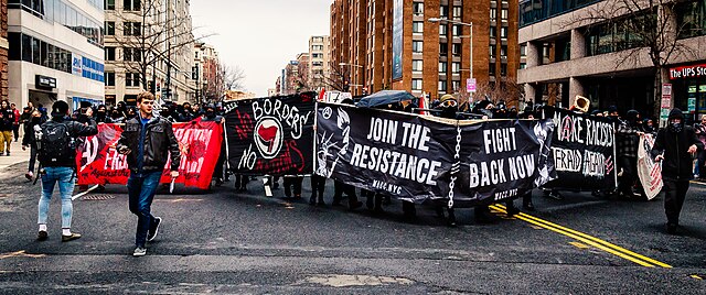 Anarchists protesting against borders with banner reading "No border, no nations"