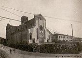 Photographie en noir et blanc d'une église située au bord d'une route.