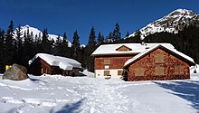 Vista del Konstanzer Hütte, que consta de tres edificios;  uno solo, los otros dos juntos en un ángulo de 90 grados;  con nieve en el techo en un ambiente nevado