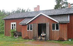 Korteniemen perinnetilan päärakennus, portailla kesäisäntä. Myös koirankoppi vasemmalla on suojelukohde.