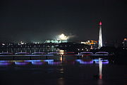 The bridge at night, along with Juche Tower to the right and fireworks for the Arirang Mass Games in background (2012)