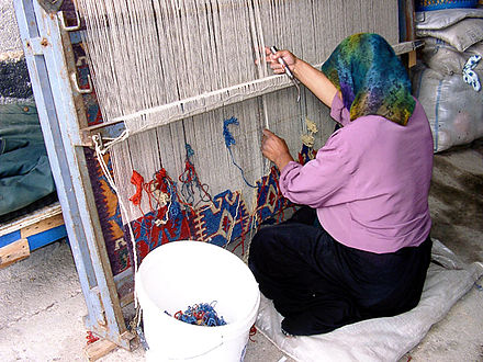 A woman in Konya, Turkey, works at a vertical loom