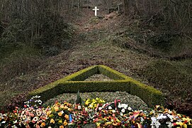 croix en pierre indiquant où la roi est mort et devant lequel a été créé un massif végétal et floral
