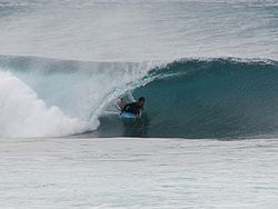Imagen de un surfista realizando un tubo.