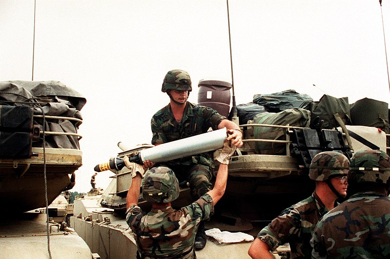 File:PFC. Edward Bessette hands a 105mm round up to SPEC. Scott Arnold as the soldiers of 1ST Bn., 64th Armor, 24th Inf. Div. (Mechanized) load ammunition aboard their M-1 Abrams tanks p - DPLA - 4a8a4c03ce5f742b2a7c919d726da32e.jpeg