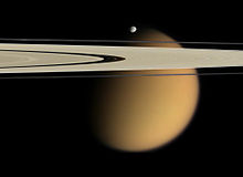 Cassini-Aufnahme von Epimetheus und Titan, aus Entfernungen von 667.000 bzw. 1,8 Mio. km, die gut die Größenverhältnisse der beiden dokumentiert.