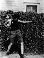 English: Teen-aged Robert E. Howard, posing with boxing gloves by the side of his home.