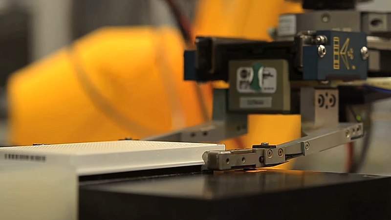 File:Robot arm handles an assay plate.jpg