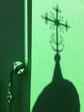 Shadow of the cross on green wall