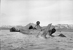 German battleship Tirpitz lying capsized in Tromso fjord after the Operation Catechism air raid, attended by a salvage vessel. Tromso, Royal Air Force Bomber Command, 1942-1945 CL2830.jpg