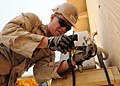 US Navy 090515-N-9410R-088 Utilitiesman 3rd Class Jacob Phelps, assigned to Naval Mobile Construction Battalion (NMCB) 5, connects a pipe from an air conditioning unit to a condenser.jpg
