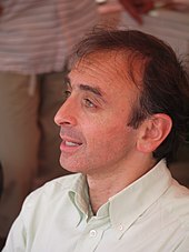 Photo d'un homme en chemise blanche avec le col ouvert.