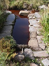 Lavoir entouré de pavement en schistes ardoisiers.