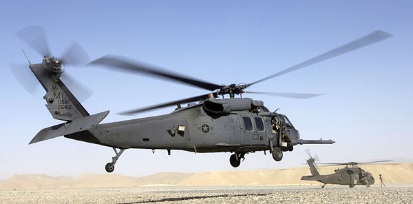 An HH-60 Pave Hawk helicopter lands as an Army UH-60 Blackhawk prepares to pick up a patient