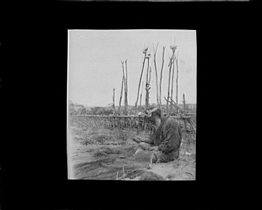 File:Ainu man seated outside working on nets LOC agc.7a10178.tif