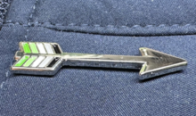 A pin depicting an arrow with the fletching representing the Aromantic Pride flag colors Aromantic Arrow Pin.png