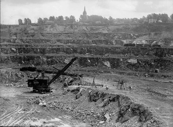 Canada's biggest power shovel loading an ore train with asbestos at the Jeffrey Mine, Johns-Manville Co., Asbestos, Quebec, June 1944