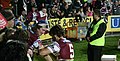 A Manly Sea Eagles NRL player autographs a fan's arm