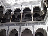 Ornate designs on walls, arches and columns surrounding an inner courtyard