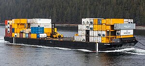 A barge headed to Alaska carrying containerized cargo Barge headed to Alaska (9230206599).jpg