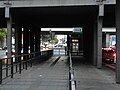 Sous le pont de la gare avec accès ascenseur.