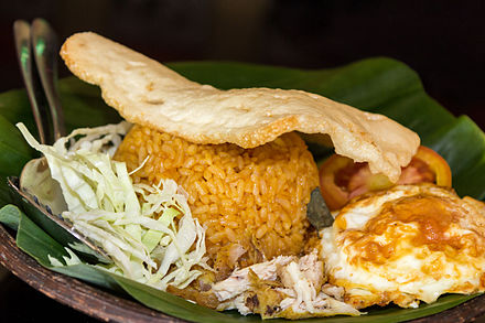Indonesian nasi goreng with chicken, fried egg, prawn cracker and vegetables