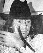 Czarno-białe zdjęcie mężczyzny w czarnym kapeluszu.