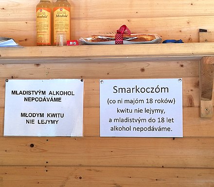 Goral Silesian lect and Czech in Cieszyn, Poland. The text notifies that people under the age of 18 will not be served alcohol.