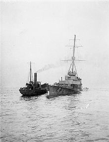 A tug alongside the wreck of Arethusa after Arethusa was badly damaged by a mine off Felixstowe, 11 February 1916 HMS Arethusa (1913) mined.jpg