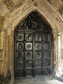 The south porch doors are by the architect Henry Wilson. A complex work in bronze, the door contains 10 panels with New Testament scenes, and two door handles with cherubic heads. A further eight heads are on the cross pieces. Above, Christ and angel with doves. HenryWilsonBronzeDoors.JPG