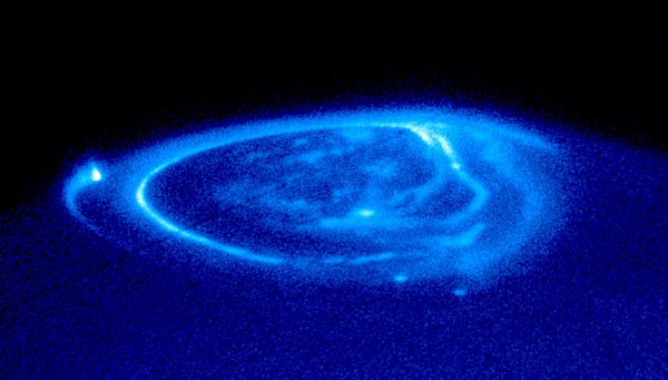 Ultraviolet image of Jupiter's aurora; the bright spot at far left is the end of field line to Io; spots at bottom lead to Ganymede and Europa.