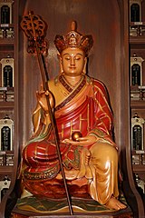 A statue of bodhisattva Kṣitigarbha holding a cintamani stone and a ring staff