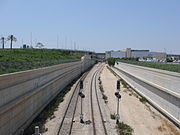 מבט אל טרמינל 3 ממזרח. במרכז התמונה נראית המסילה הנכנסת אל תחנת הרכבת מכיוון מודיעין וירושלים, וחלק מהכביש המוביל על גבי גשר אל אולם הנוסעים היוצאים (משמאל למעלה)