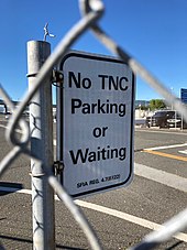 Airports in California, such as the San Francisco International Airport, regulate where TNC (Transportation Network Companies - the legal term for rideshare companies in California) vehicles may pick up, drop off, or wait for passengers. No TNC Parking or Waiting sign, San Francisco International Airport cell phone lot.jpg