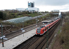 Kilátás délkeletről, a STEP ipari park és az Österfeldtunnel melletti buszmegálló a Nord-Süd-Straße-n.  A háttérben az egyetem ÉNY -ja (természettudományok)