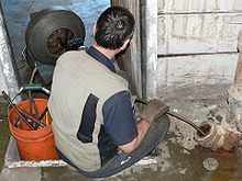 A man clears a sanitary sewer pipe with a motorized snake. Plumbers snake 24689.jpg