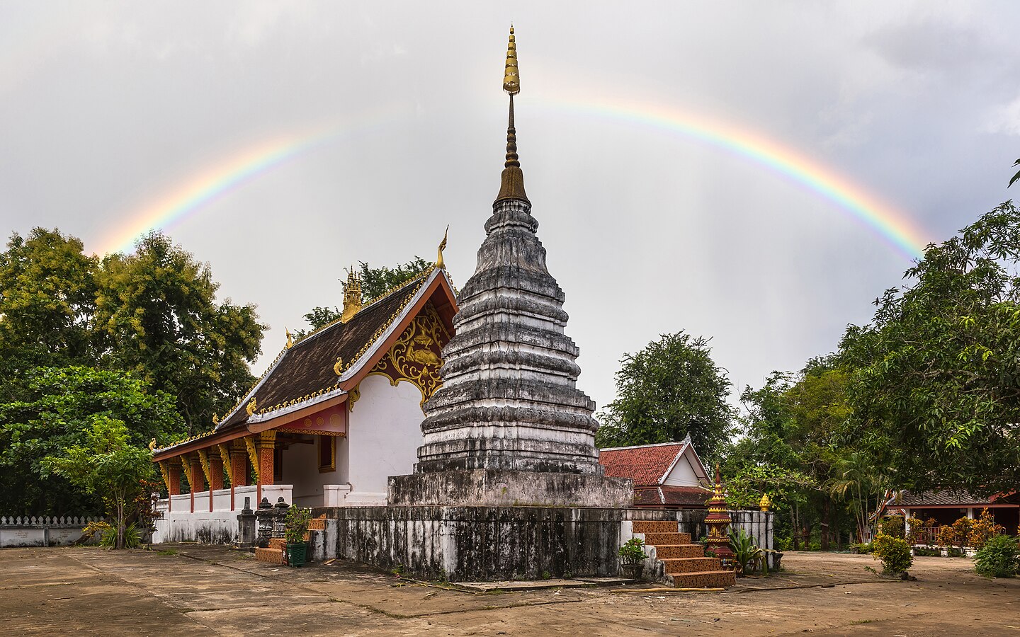 Rainbow over stupa at Wat Phone Sa Ath Phatiya Moungkoun bouddhist temple in Luang Prabang Laos