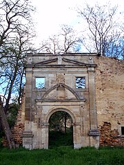 Egy klasszikus barokk portál fényképe szinte ép, de egy romos épületbe illesztve.