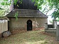 Vchod do dřevěná zvonice na hřbitově ve Skůrech.