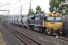 A Pacific National train on the line passing through Sefton TT104 trailing on a Pacific National Minerals train in Sefton, New South Wales.jpg