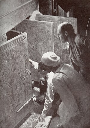 Հովարդ Քարթերը բացում է Թութանհամոնի գերեզմանը։ Նրա ետևում եգիպտական աշխատակիցն է և Արթուր Քալլենդերը